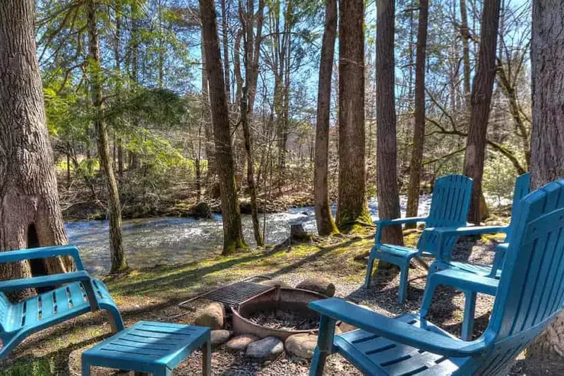 4 blue lounge chair outside in a circle around a fire pit