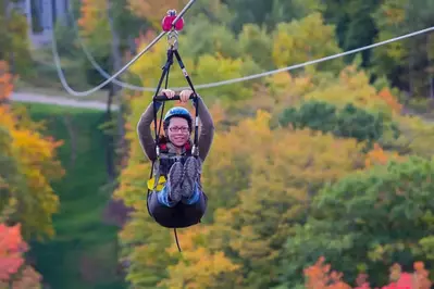 woman ziplining in the fall