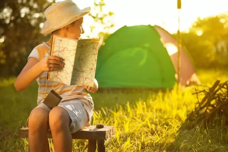 Child reading map while tent camping in Smoky Mountains at Greenbrier Campground