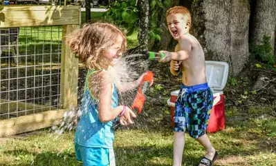 Two kids having a water fight