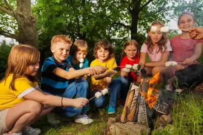 Kids making s'mores around a campfire
