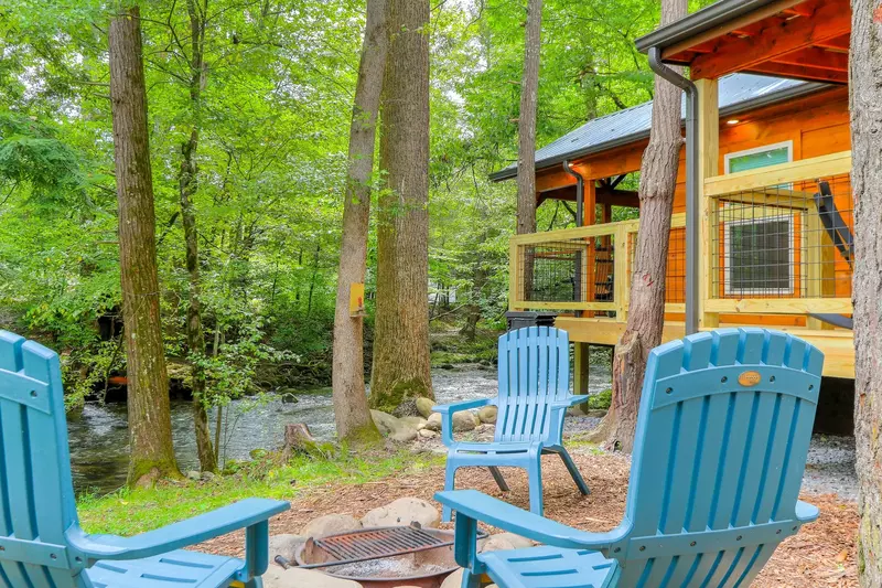 Chairs around fire ring outside Deluxe Camping Cabin